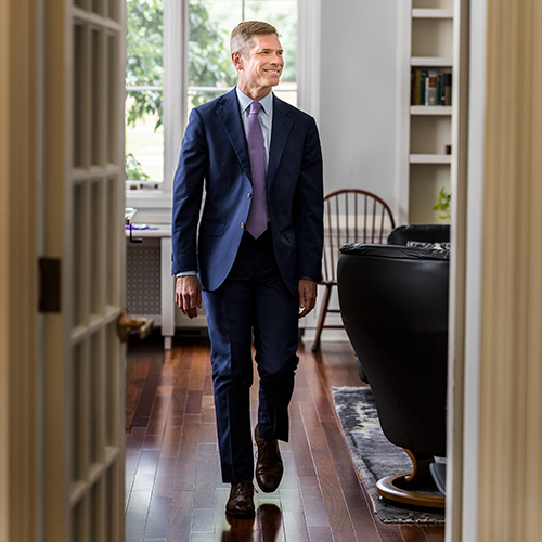 A man in a suit walking in an office