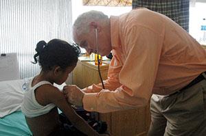 John Howe III '65 with a patient