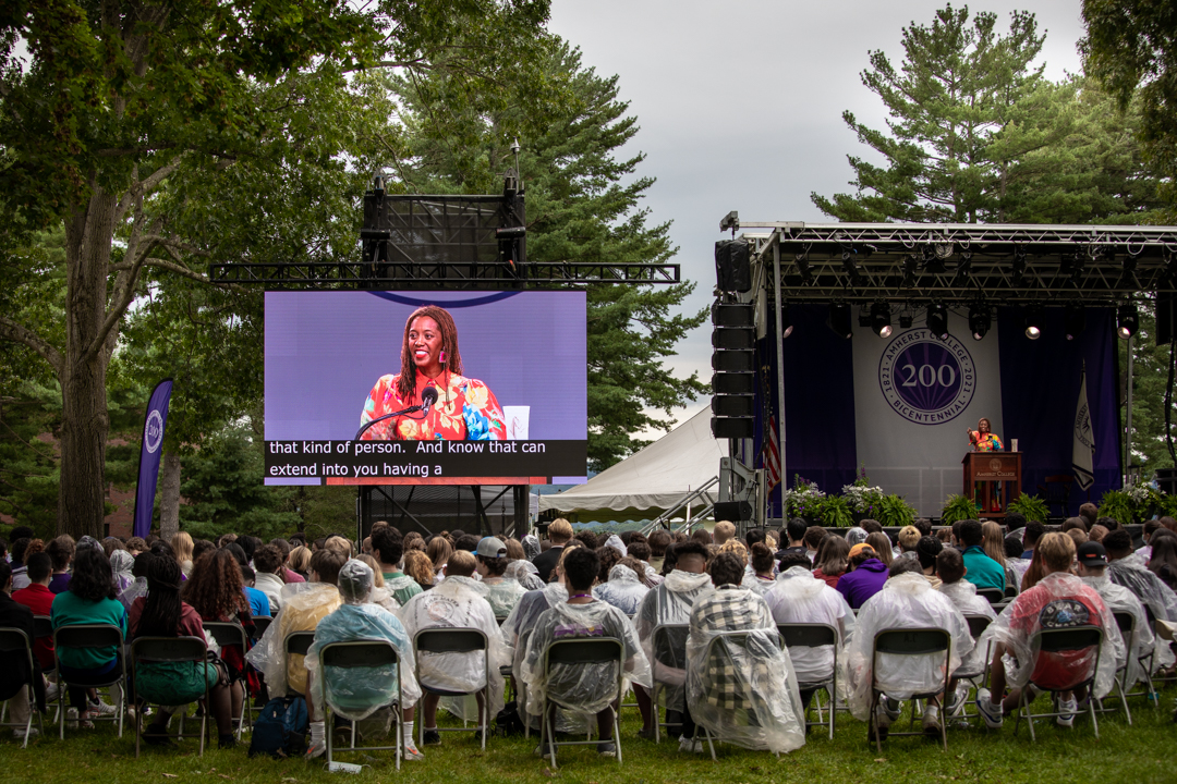 Professor Shayla Lawson on a screen speaking on the Amherst College quad