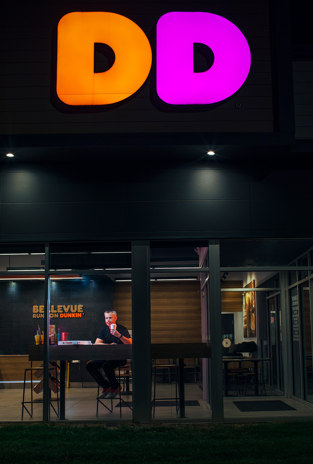 A man in a darkly lit Dunkin Donuts