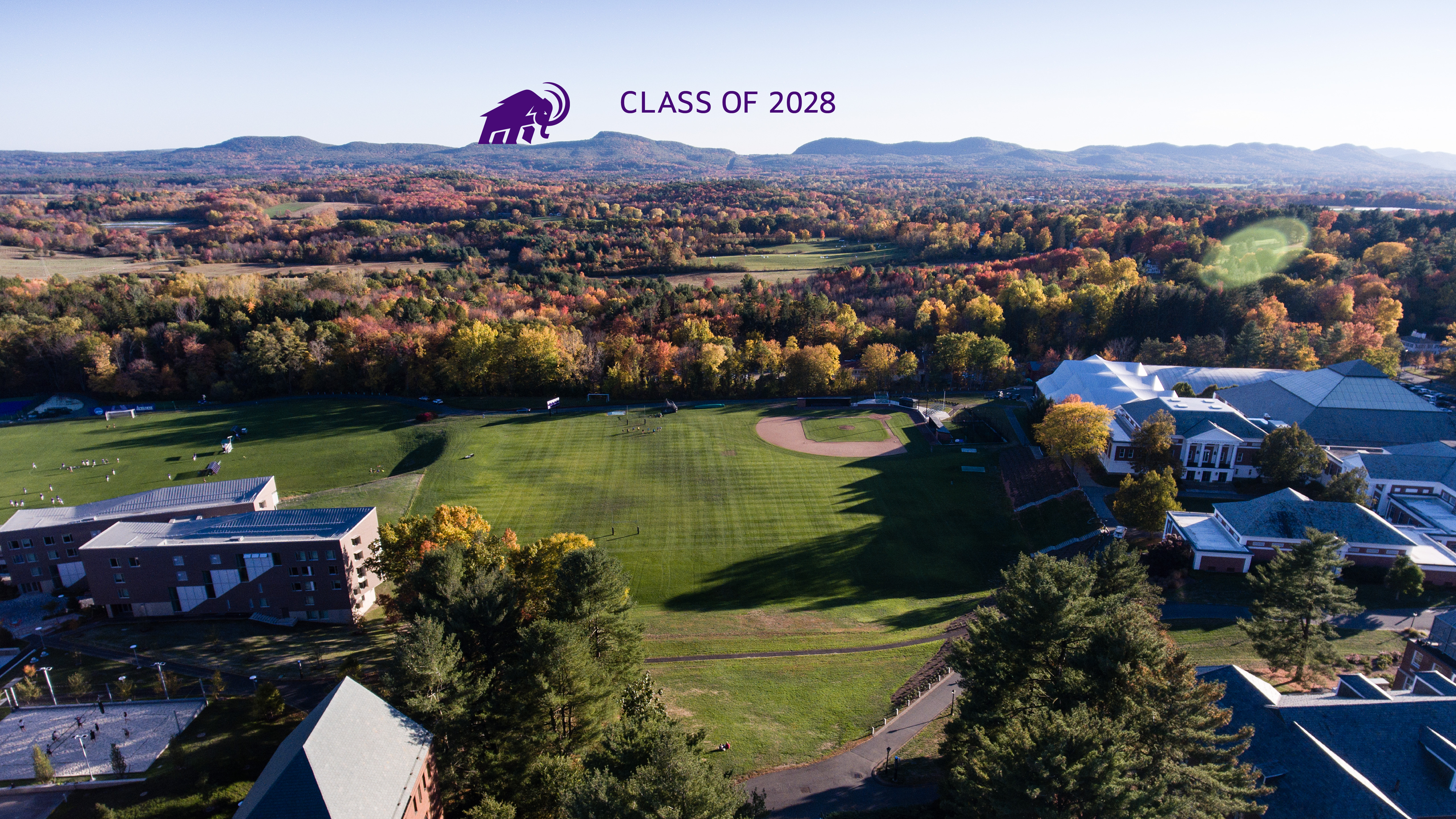 The Amherst Mammoth walking along the Holyoke Range with the words Class of 2028 in the sky