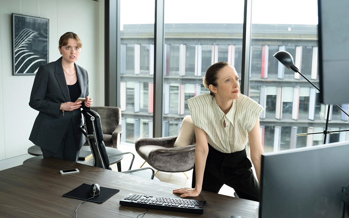 Two women in a modern office at a desk with a computer