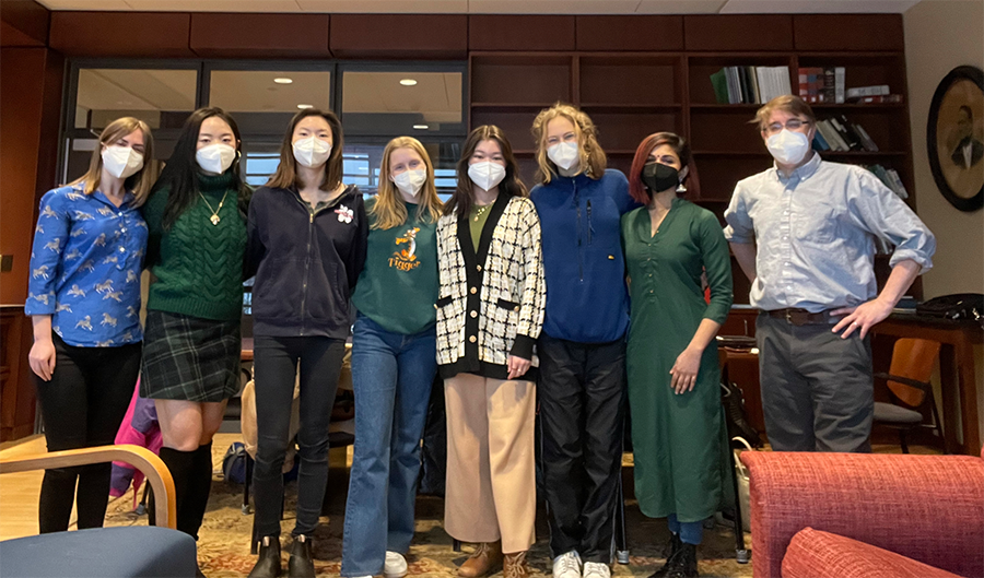A line of people in an office wearing masks
