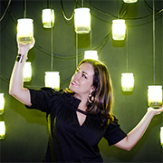 A woman reaching up and holding bright lights