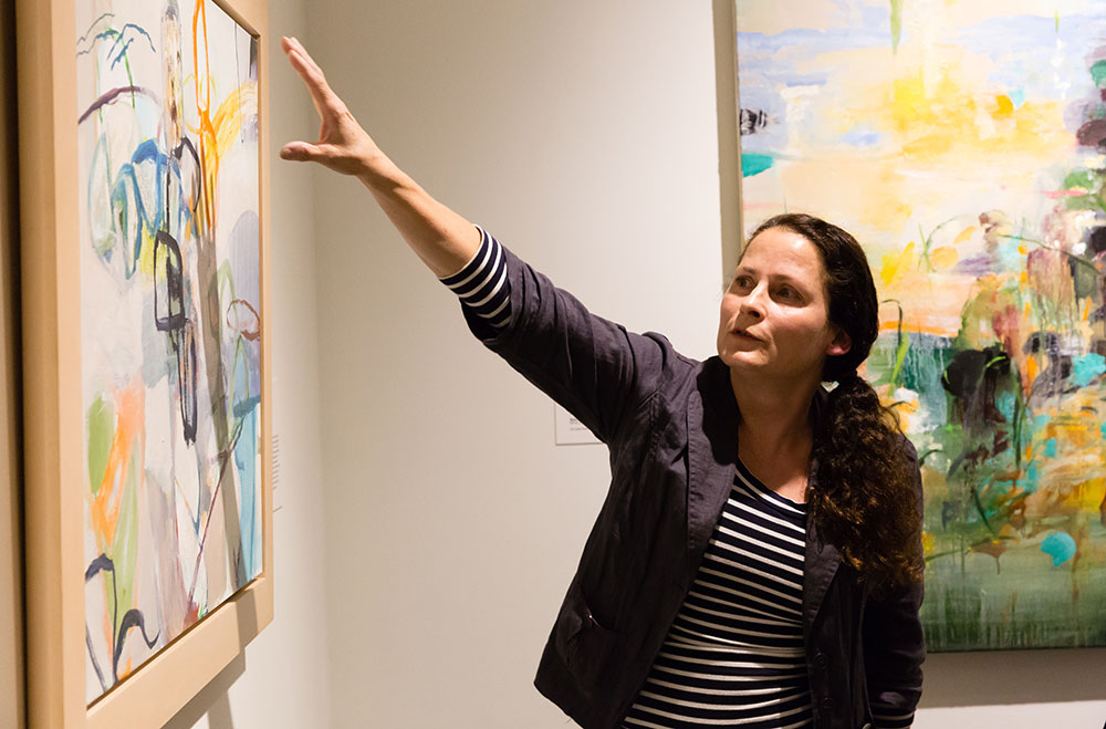 Senior Resident Artist Betsey Garand gestures towards a painting while giving a talk about the life and work of the late artist.