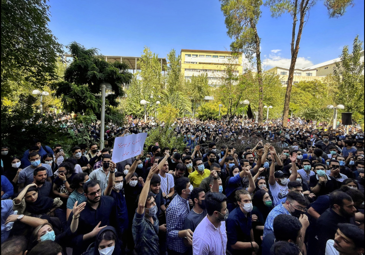 a crowd marching in protest in Iran