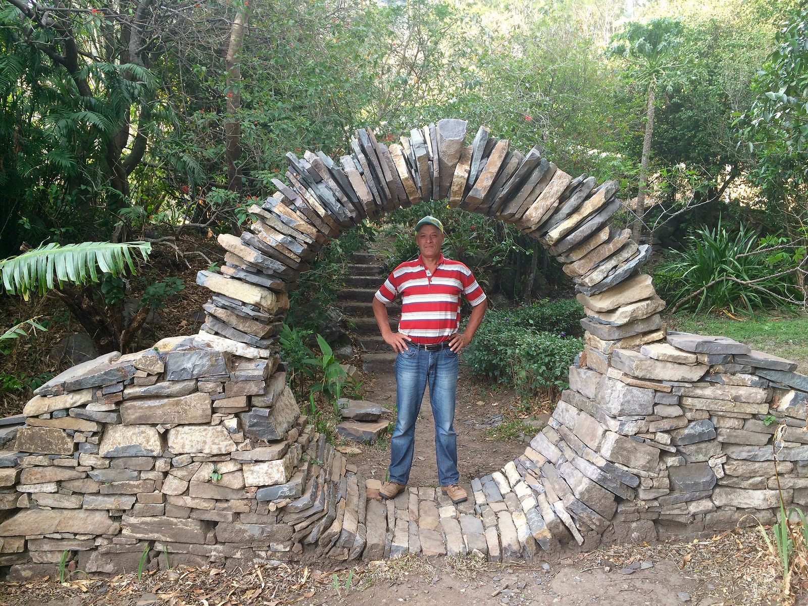 man standing in a circular arch of stones