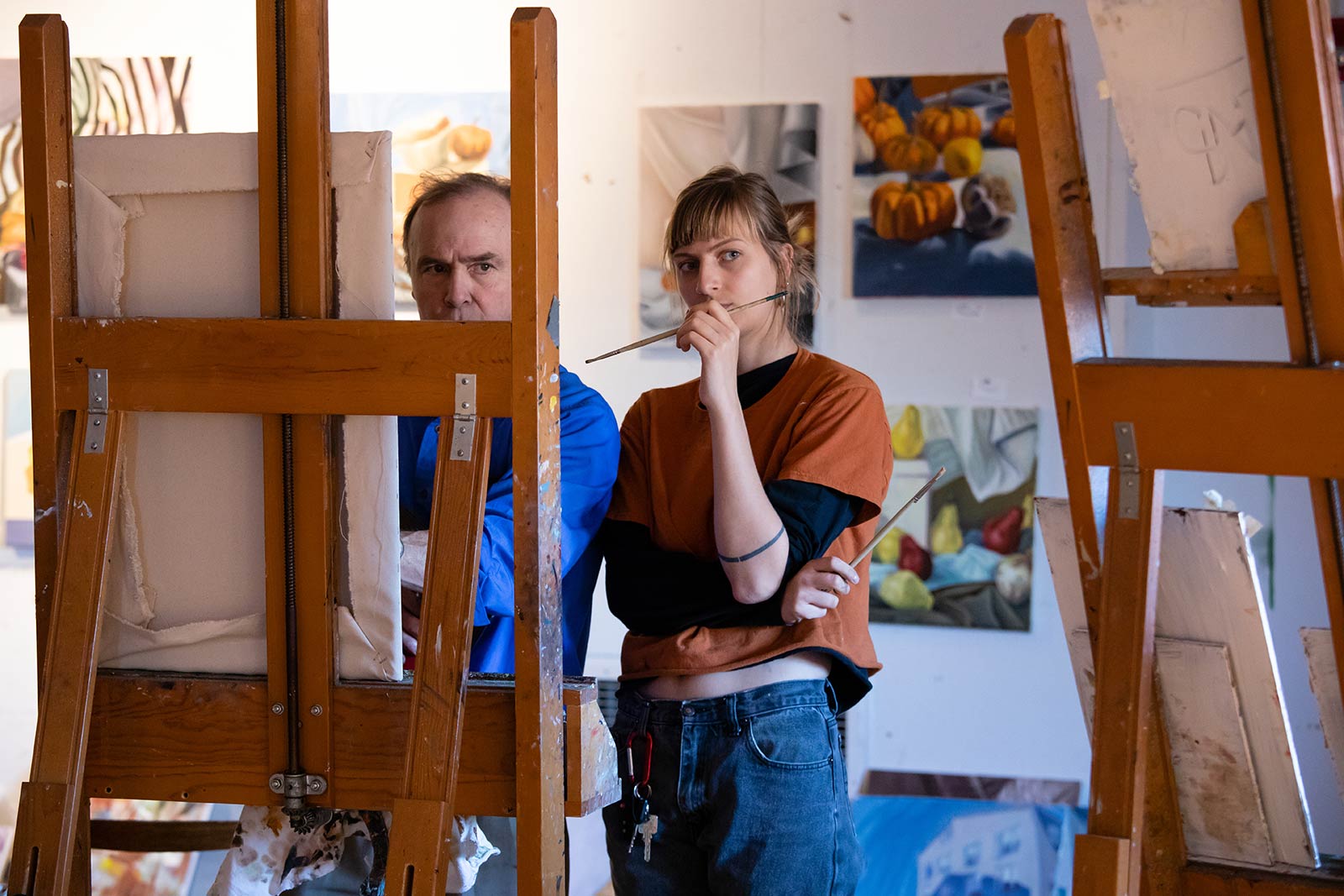 Professor Robert Sweeney and a student examine a student painting