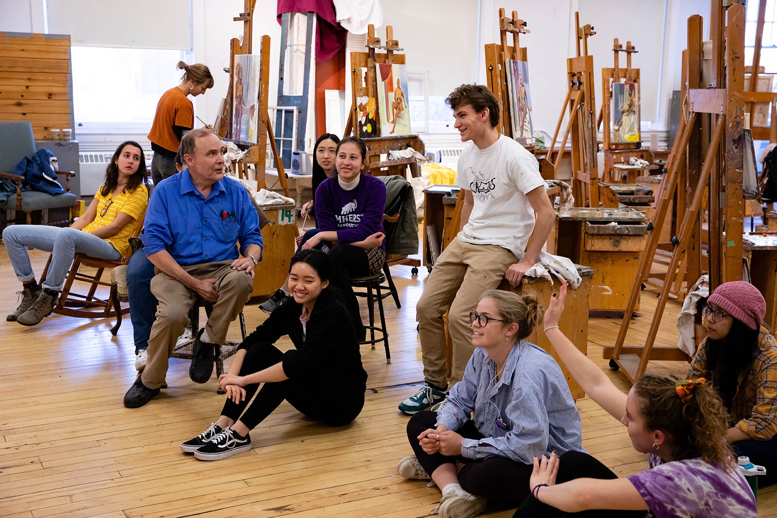 Professor Robert Sweeney talking with a group of student in the painting studio
