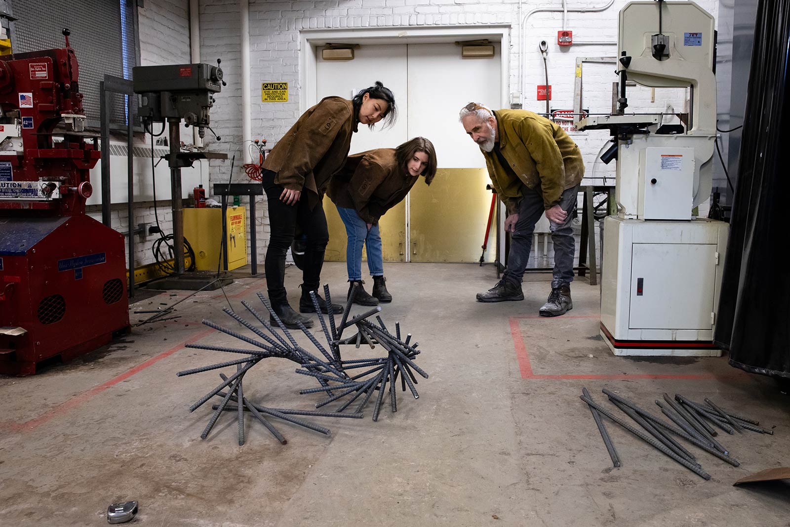Two students and Professor Culhane examine a sculpture in progress