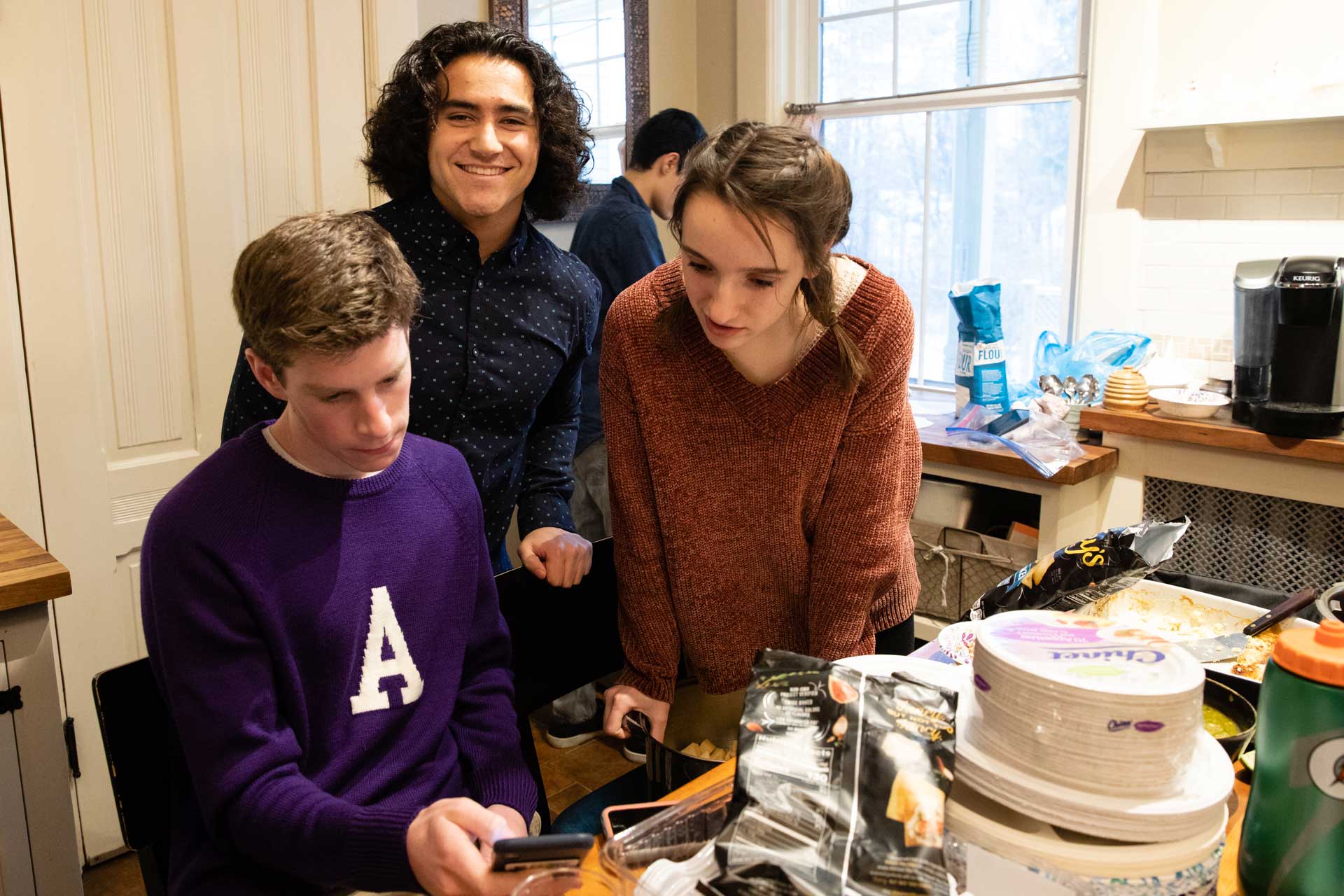 Students gathered in a kitchen preparing food