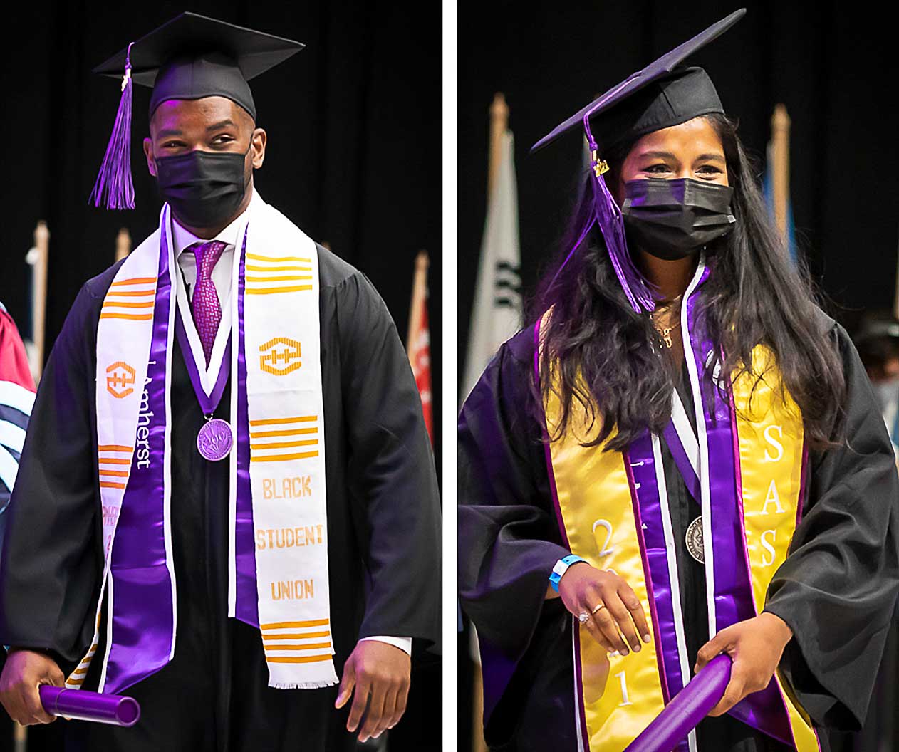 Two graduates exiting the stage after getting their diplomas
