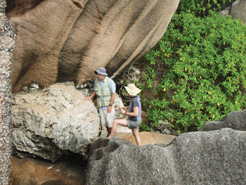 Dutton and colleague standing amid large rocks and greenery