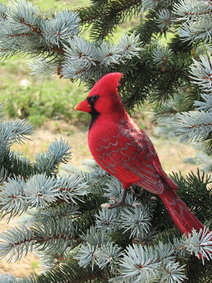 Cardinal sculpture perched in an evergreen tree