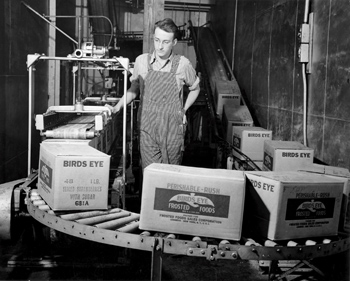 Factory worker with boxes on conveyor belt