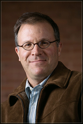 Close-up of Ilan Stavans in glasses and brown jacket