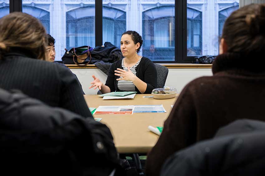 Amherst students and instructors sitting around a conference table 