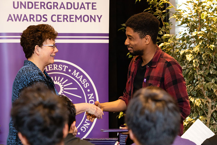 President Biddy Martin shakes the hand of an Amherst College student receiving an award