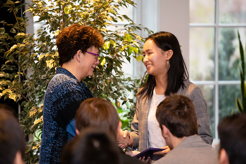 President Biddy Martin shakes the hand of an Amherst College student receiving an award