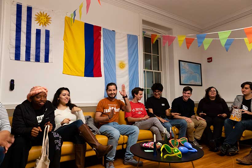College students gathered in a lounge decorated with flags from various countries