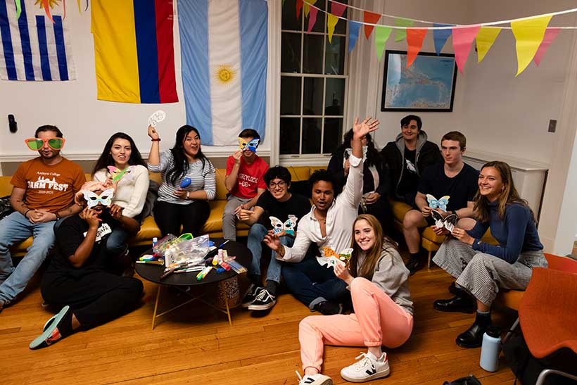 College students gathered in a lounge decorated with flags from various countries