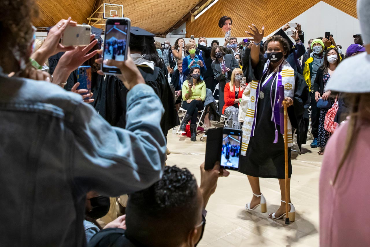 After the ceremony, Ayodele Lewis 21 waves as her father films her