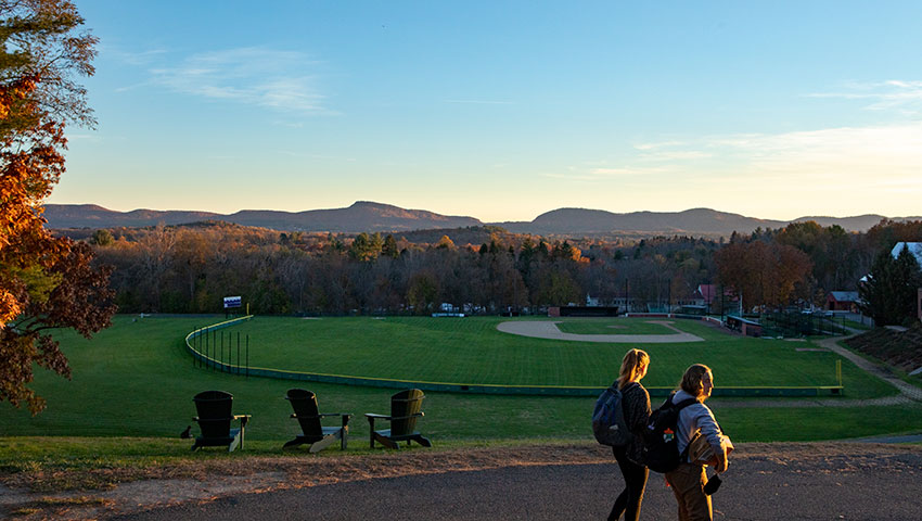 Two students walking near the top of memorial hill at Amherst College