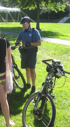 an Amherst police officer talks with students on the quad