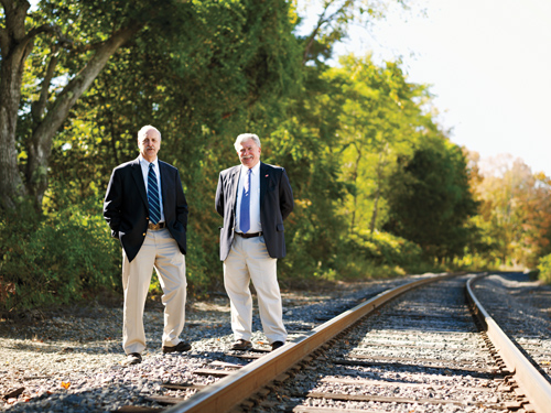 George Betke ’59 and Mike Smith ’68 standing beside railroad tracks