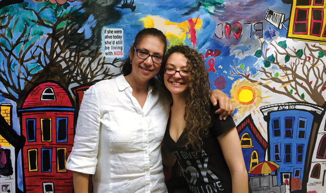 Susan and Christina Rodriquez pose in front of painted mural.