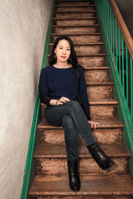 Deanna Fei '99 sitting on stairway in her home