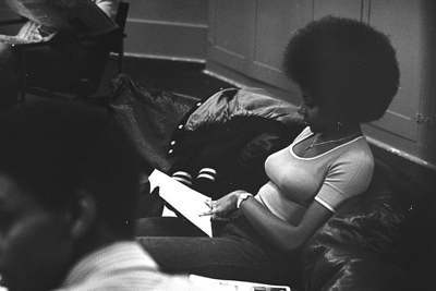 a Black woman reading, on the Amherst campus in the 1970s