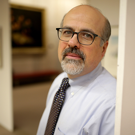 A man in glasses and a beard wearing a tie