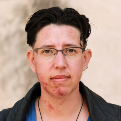 A photo of a woman with short hair and glasses