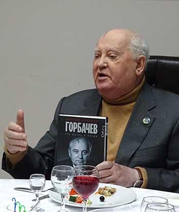 Mikhail Gorbachev holding a copy of William Taubman's biography of him