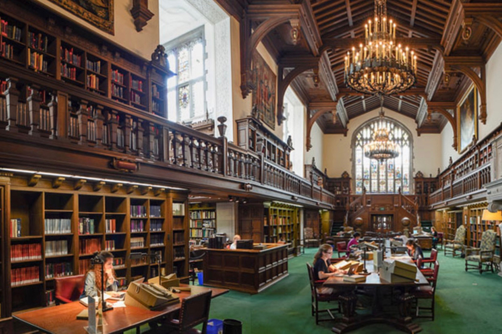 An ornate library with wood beamed ceilings and bookcases