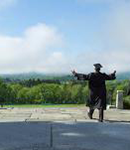 graduate in cap and gown on Memorial Hill