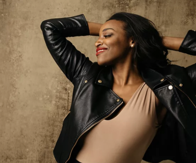 A Black woman in a leather jacket striking a dramatic pose
