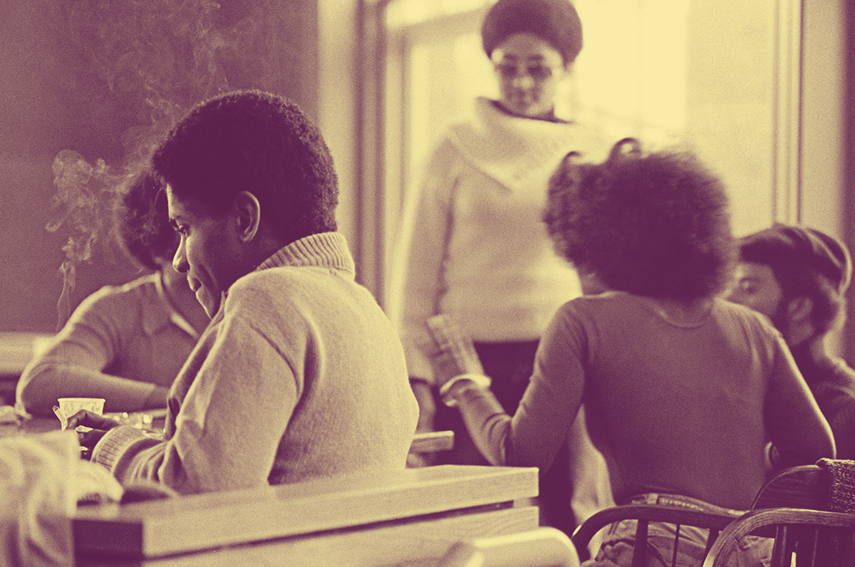 A black and white photo of Black men and women in a cafe