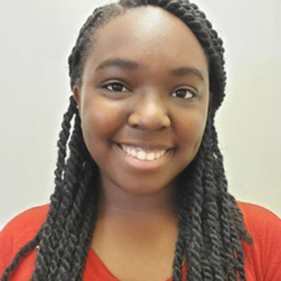 A young Black woman smiling at the camera