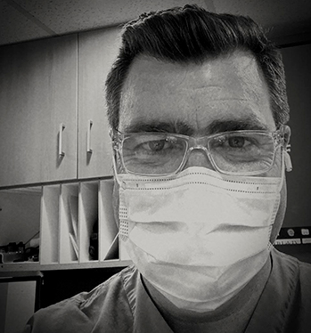 A black and white photo of a man in a medical mask