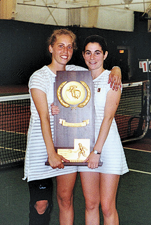 Two women tennis players holding a trophy