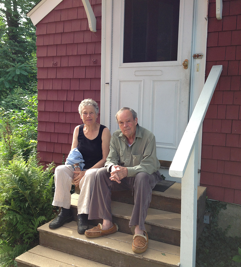A man and woman on the back steps of a home
