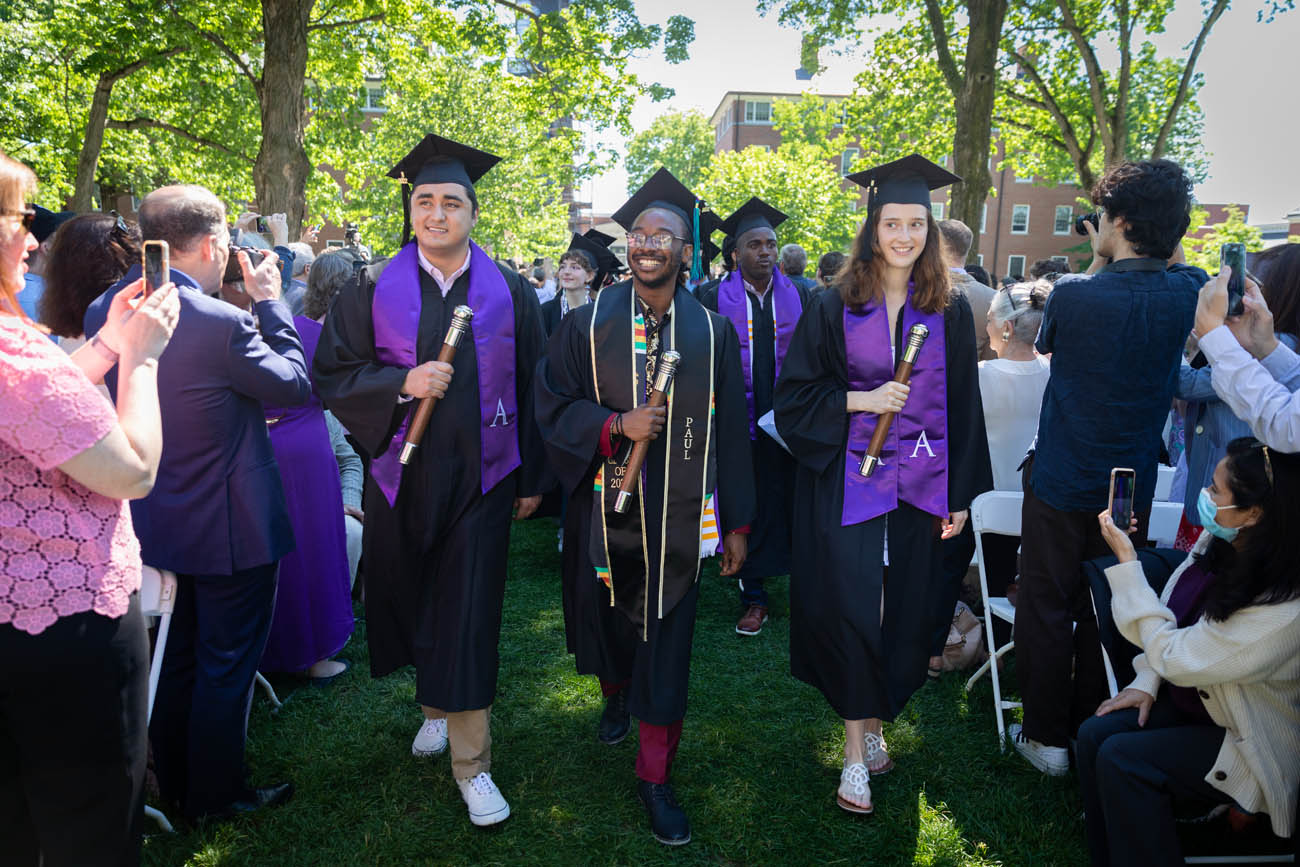 three students lead the commencement procession
