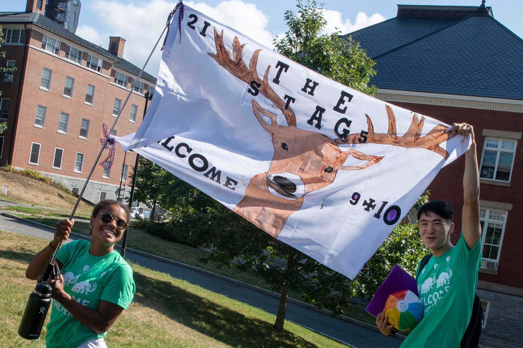 Two students hold up large banners on move-in day at Amherst College.