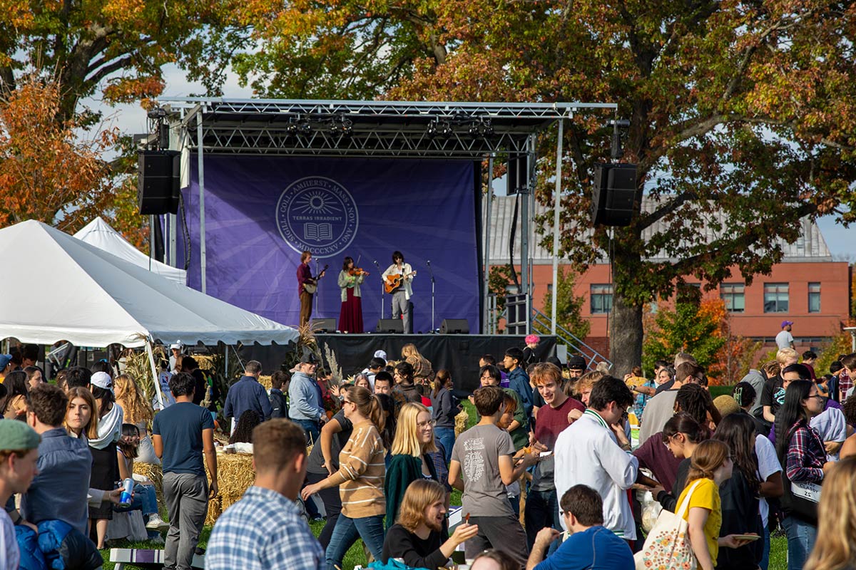 A crowd congregates on campus for food and music.