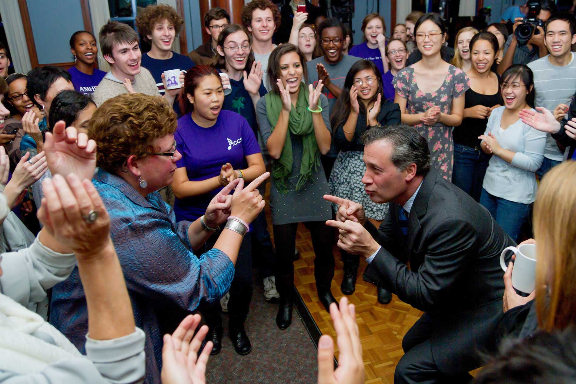 President Martin and past president Tony Marx dance playfully while surrounded by students.