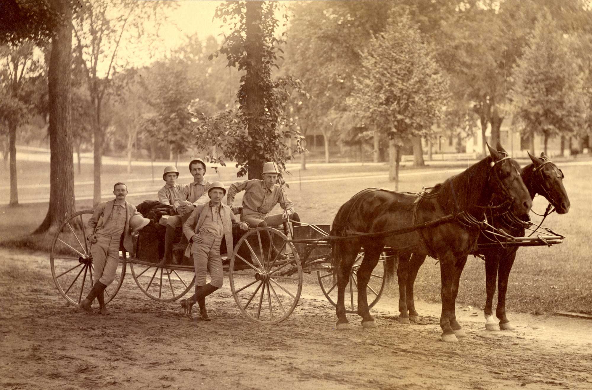 A horse dawn carriage with 5 men