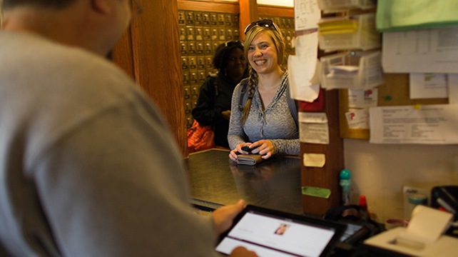 A young woman smiling at a post office counter