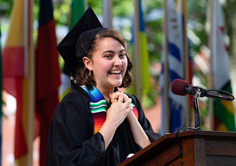 Helena Burgueño, the commencement student speaker at a podium with her hands folded together